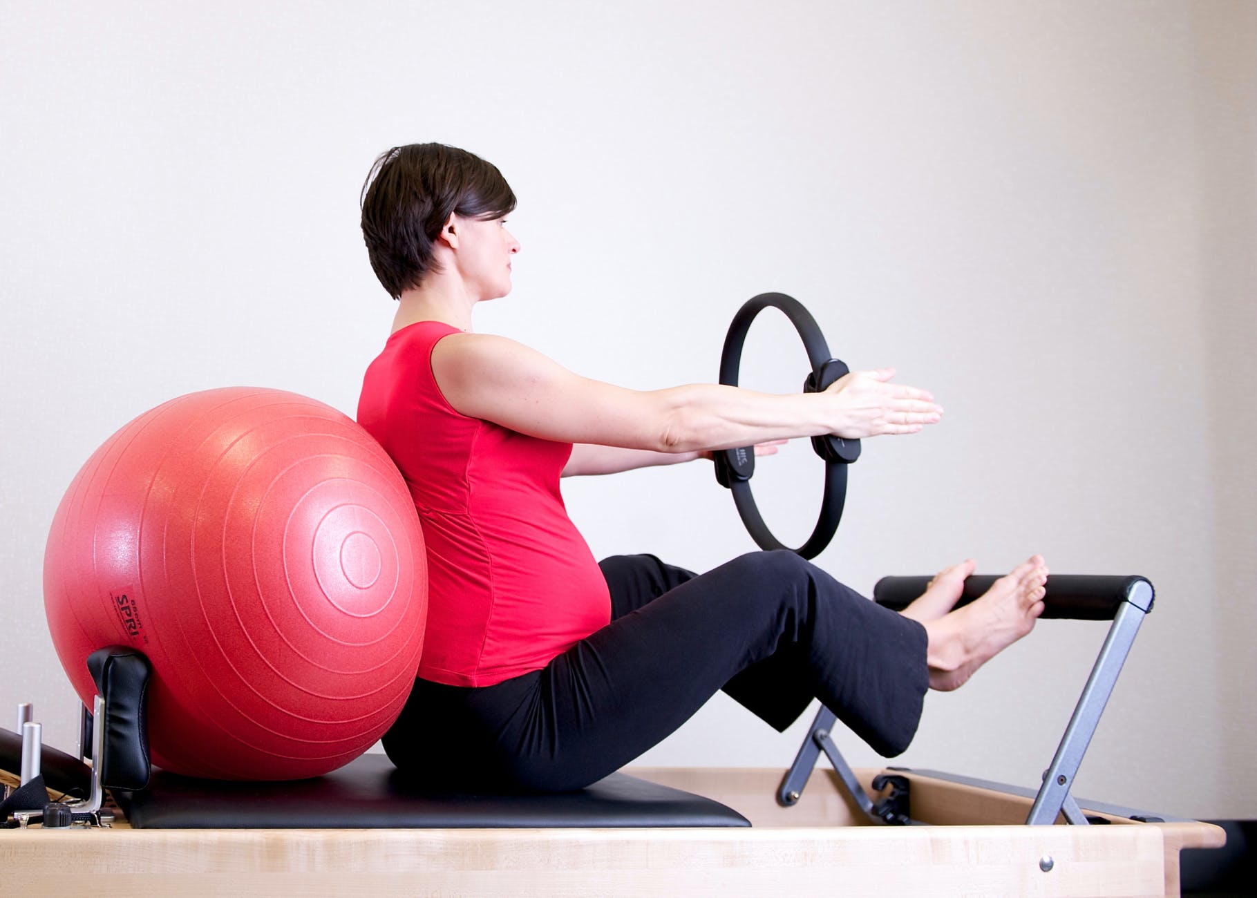 woman in red shirt sitting on fitness equipment