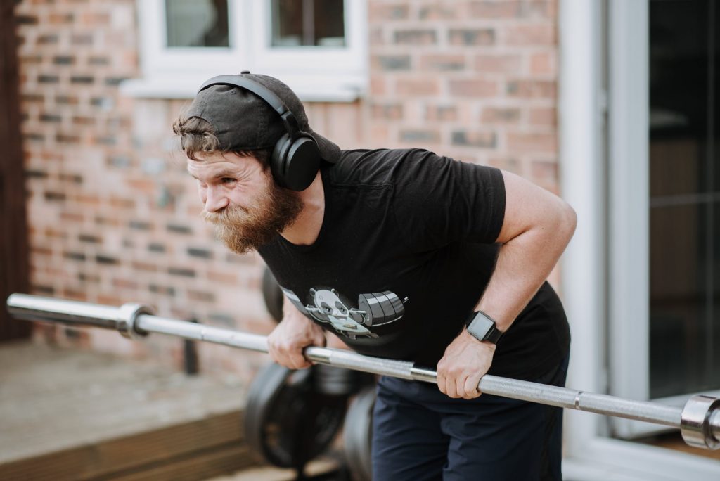 strong bearded man lifting heavy barbell