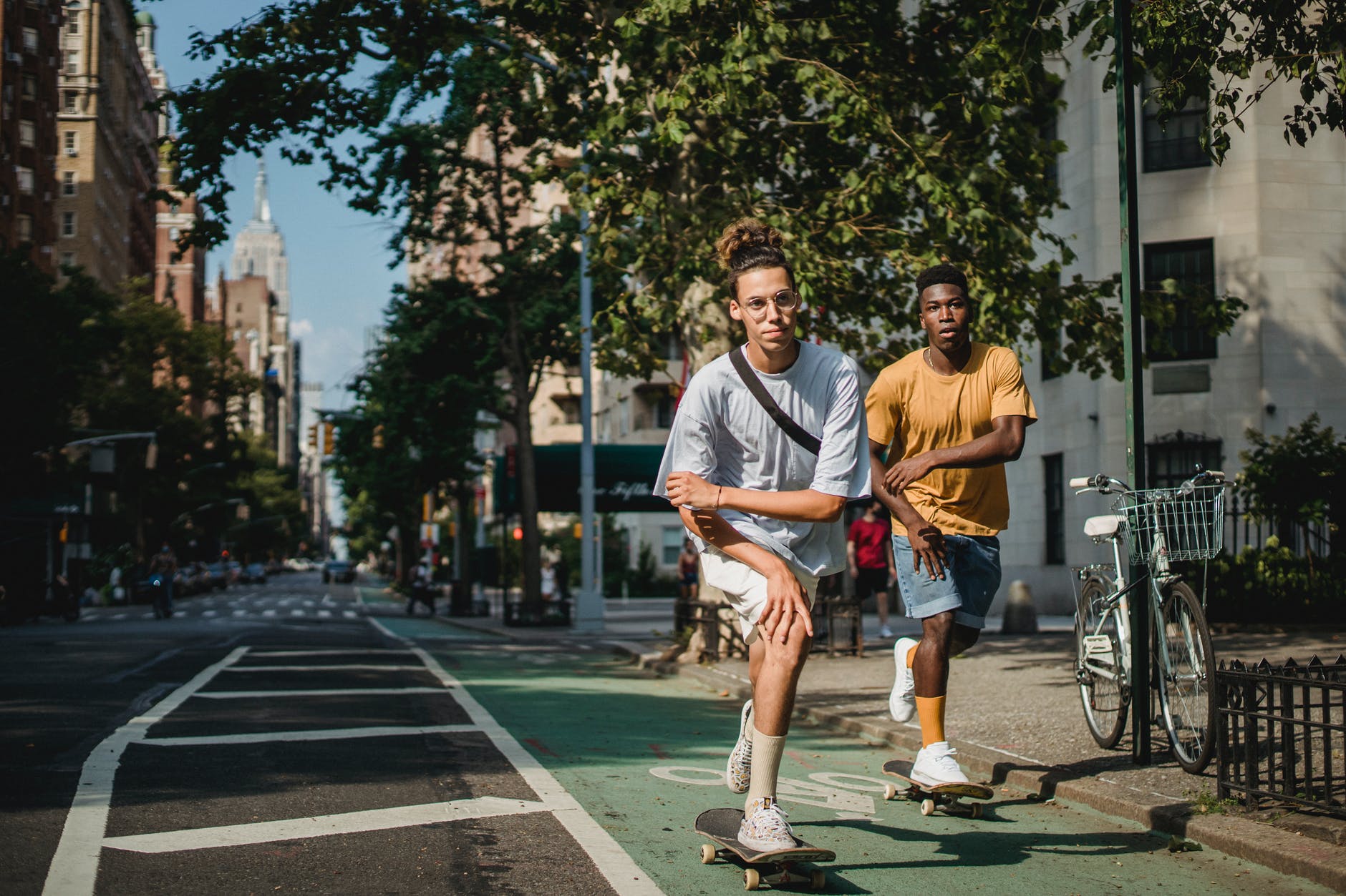 sporty young diverse men riding skateboards on road on sunny day