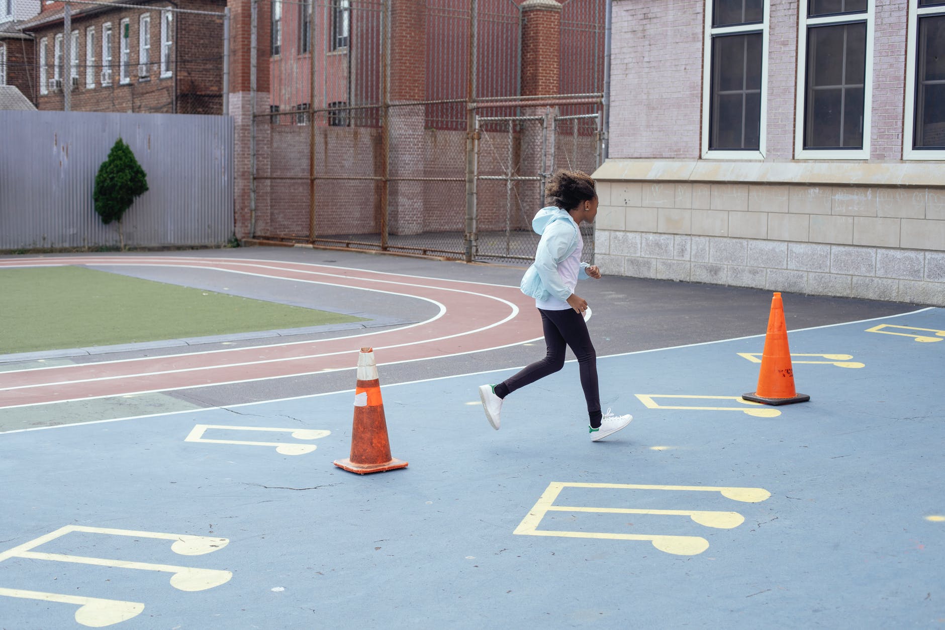 active sportive girl running fast during break on playground near school