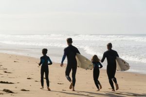a family of surfers on the beach