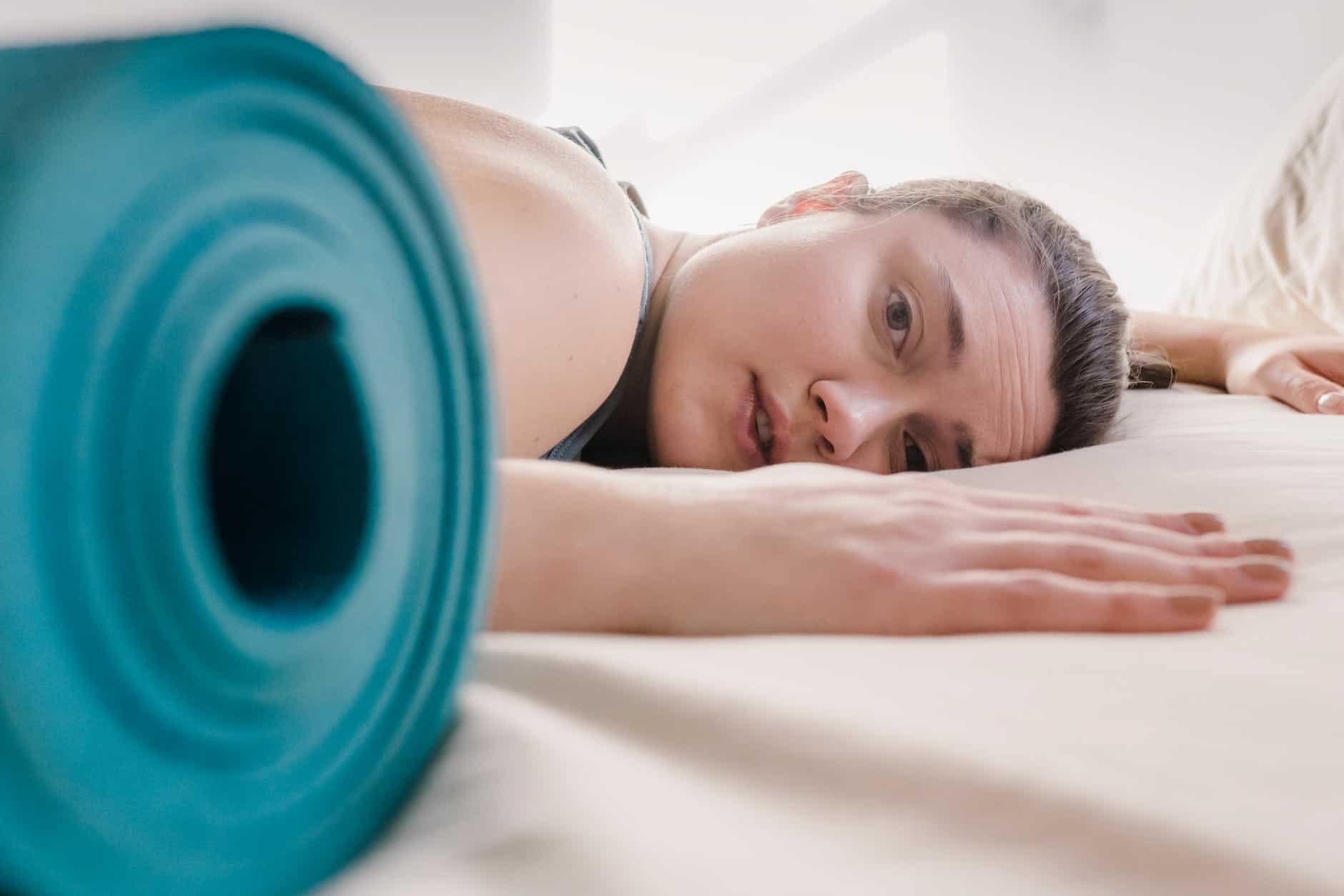 tired woman lying on bed during workout