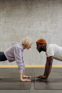 man and woman doing push up face to face