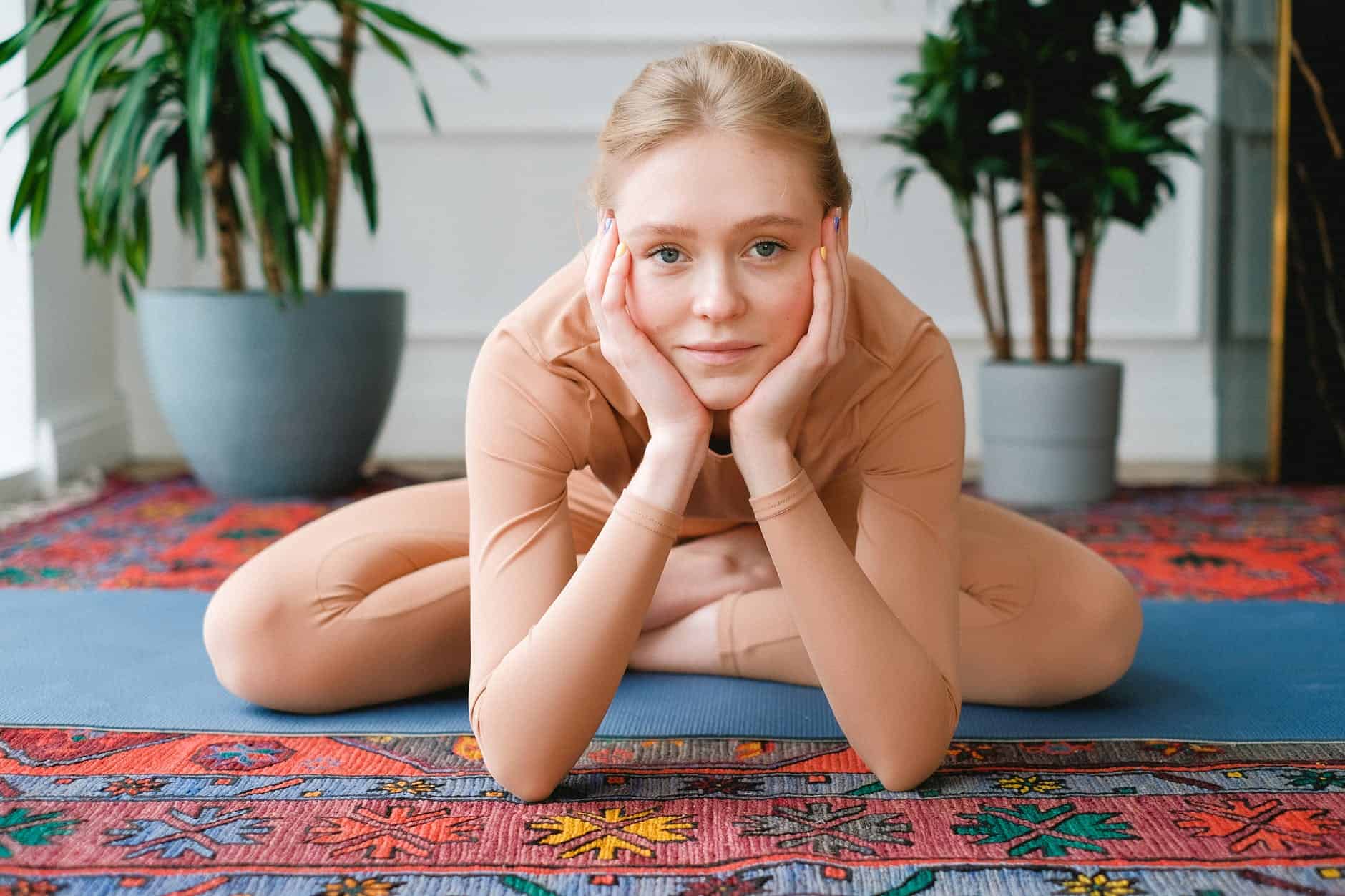 flexible woman sitting in lotus pose and leaning on hands