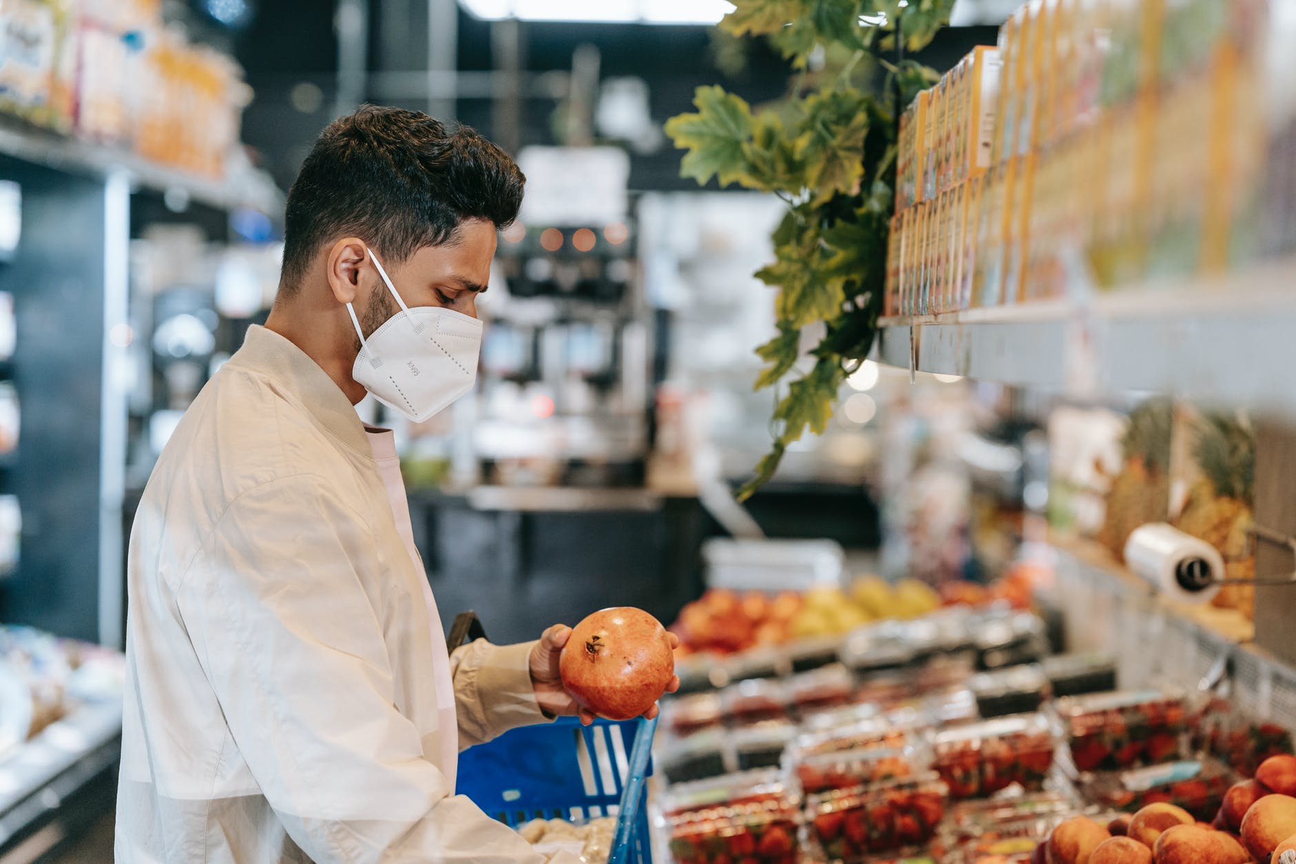 customer in mask buying fruits in supermarket