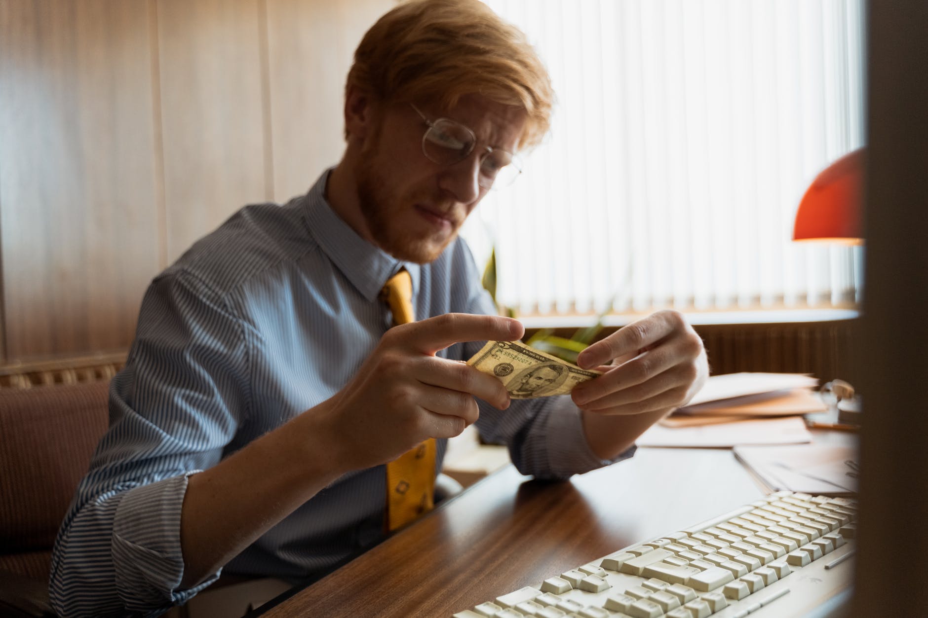 man in blue dress up shirt looking at money