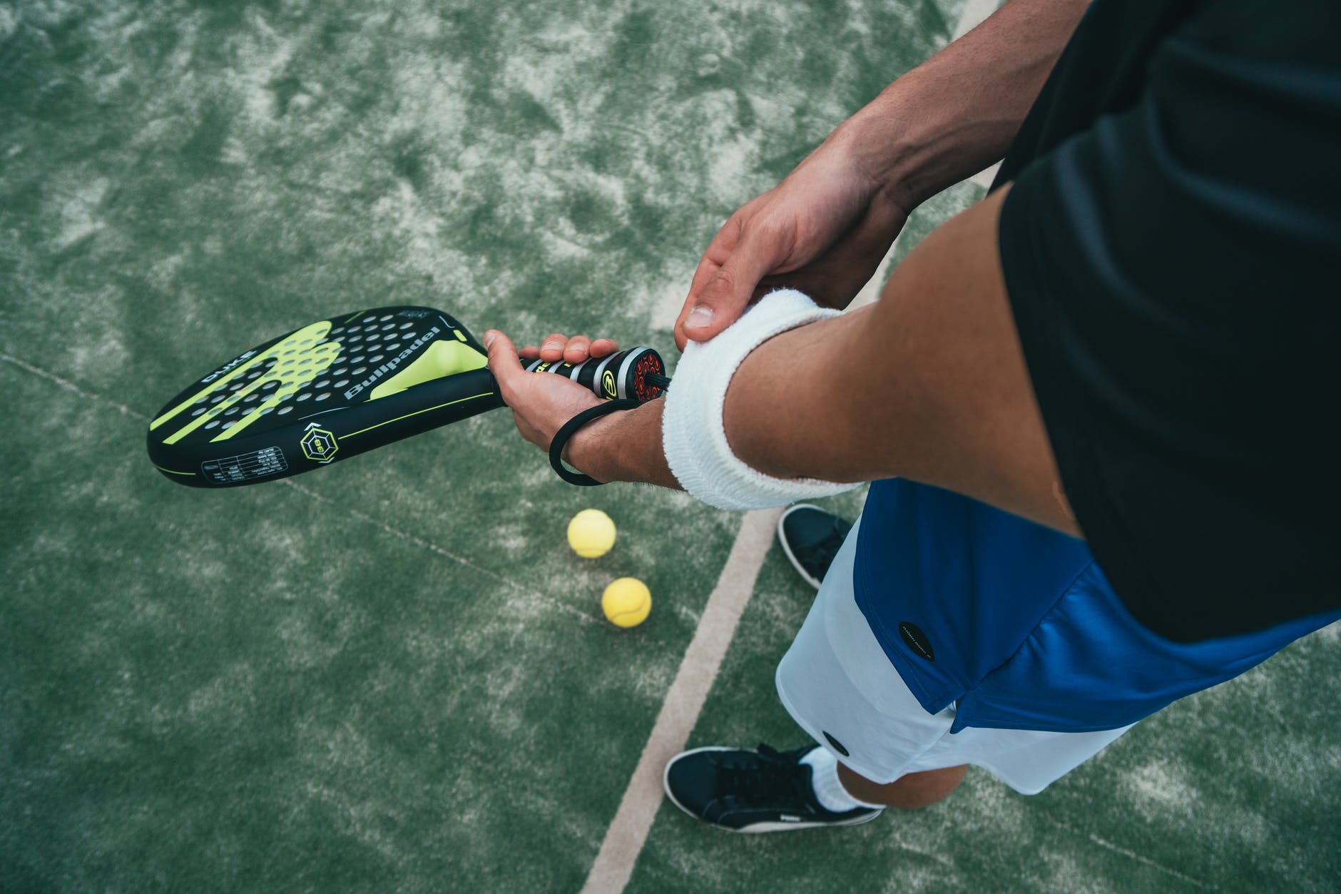 person holding black and green tennis racket