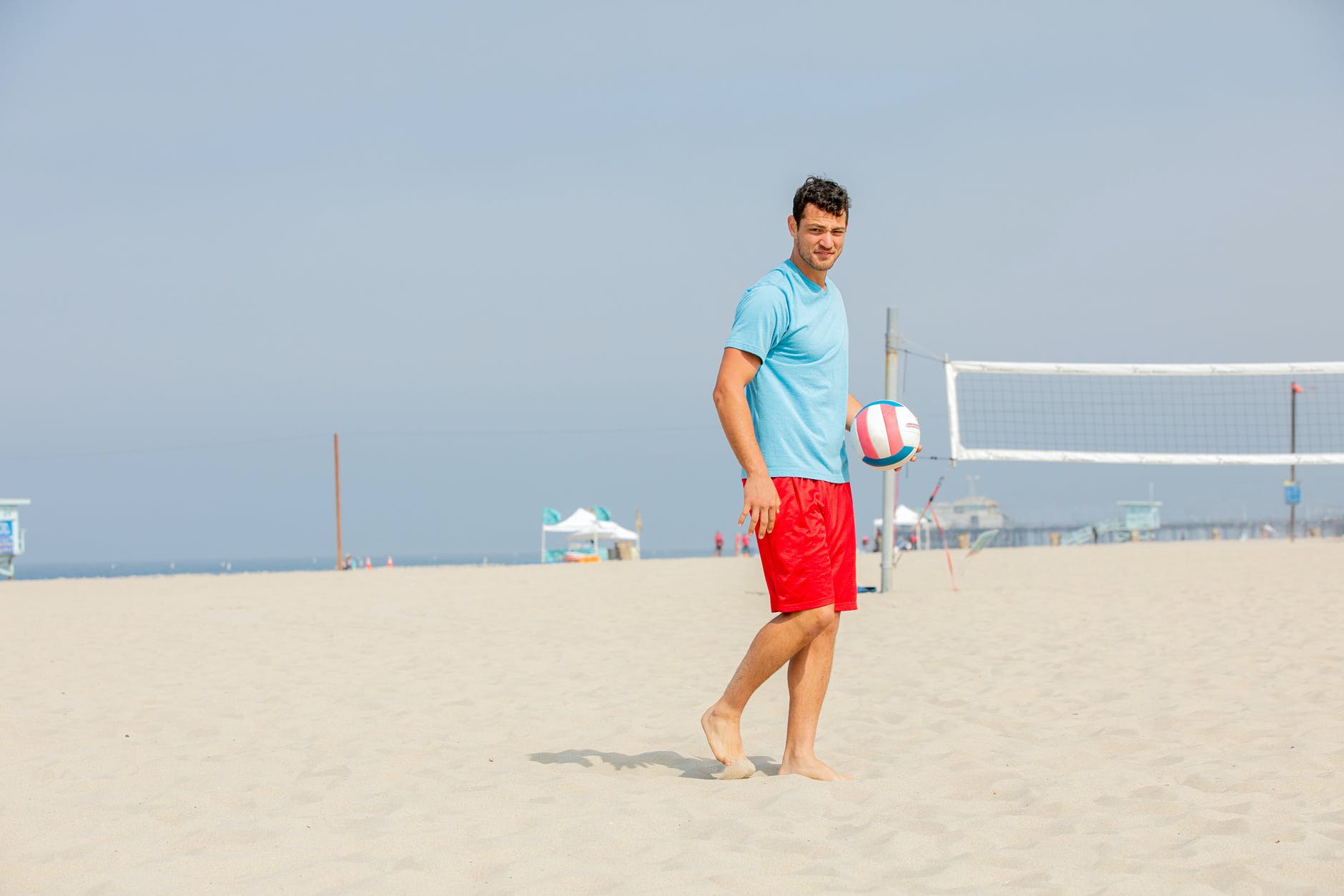 young man getting ready to serve ball on beach